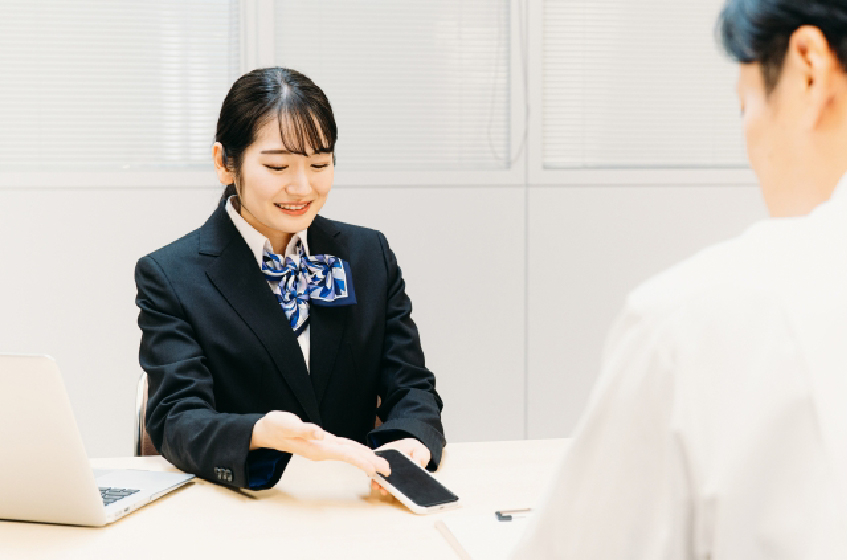 女性がスマートフォンの説明をしている画像